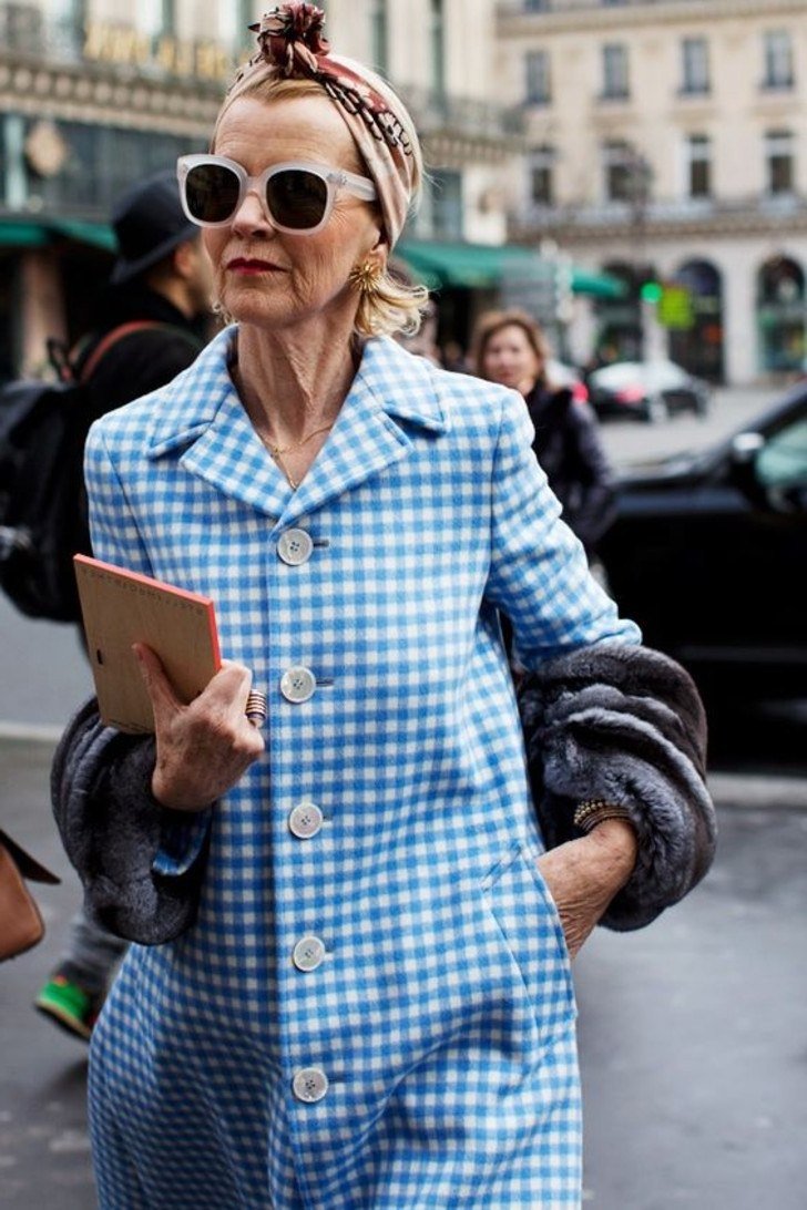 Senior woman in blue gingham coat with headscarf and sunglasses