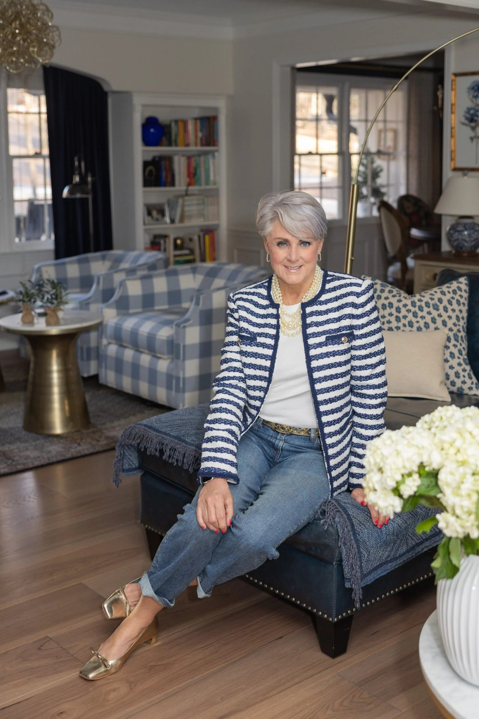 Senior woman in navy striped jacket and jeans, seated