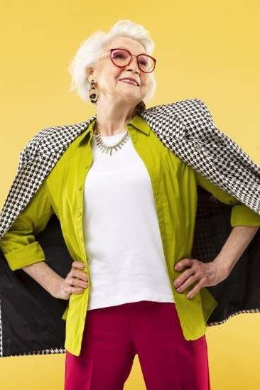 Older woman in lime blazer, white top and magenta pants