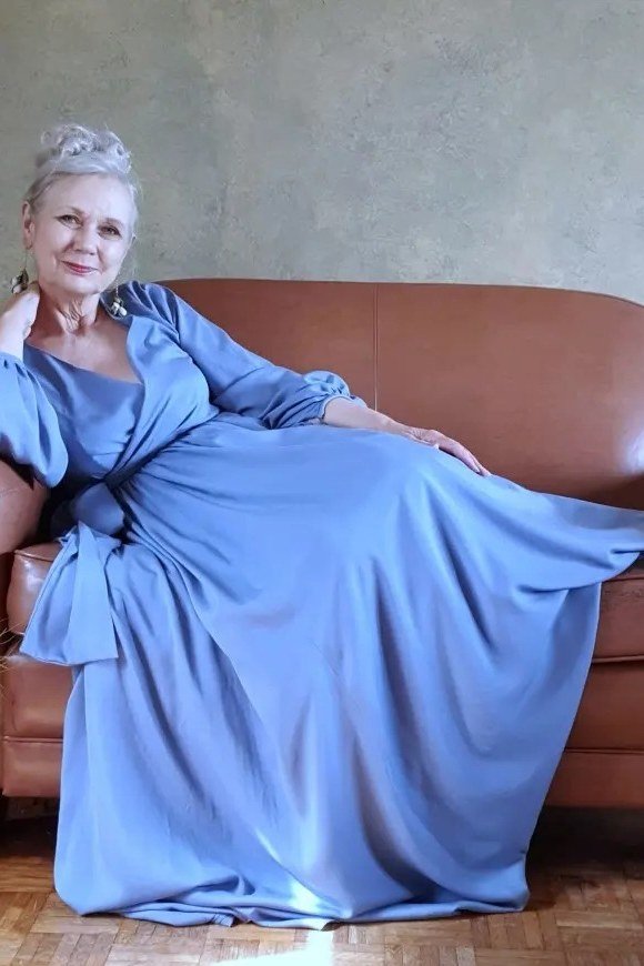 Senior woman in periwinkle blue maxi dress on a couch