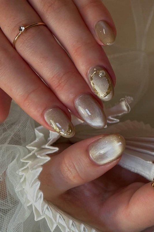 Gold cat eye shimmer almond nails with pearl accent nail and gold swirl frame, romantic gold wedding nails