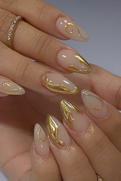 Artistic gold swirl French tip nail art on nude almond nails, modern gold wedding nails