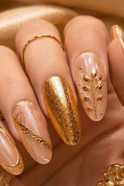 Gold botanical leaf nail art with one solid textured gold nail, floral gold wedding nails