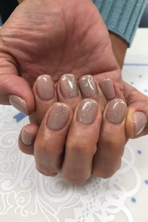 sheer nude glossy nails on mature hand, elegant neutral manicure