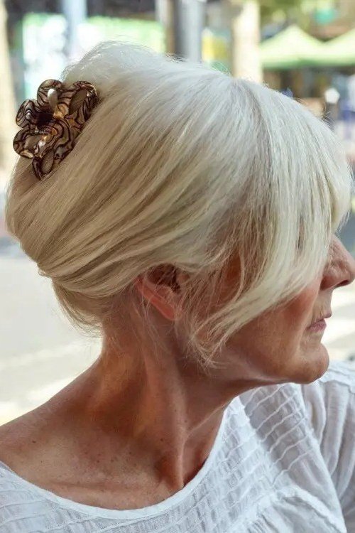 White-Blonde French Twist With Copper Flower Clip - Christmas party hairstyle for women over 60 (white-blonde french twist with copper flower clip, side view)