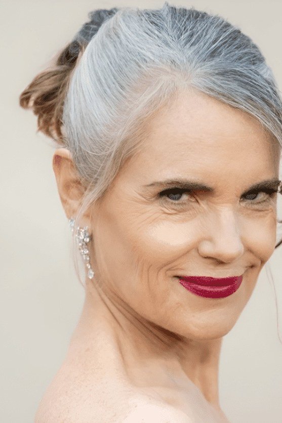 Silver-Gray Low Ponytail With Red Lipstick - Christmas party hairstyle for women over 60 (silver-gray low ponytail with red lipstick, front three-quarter view)