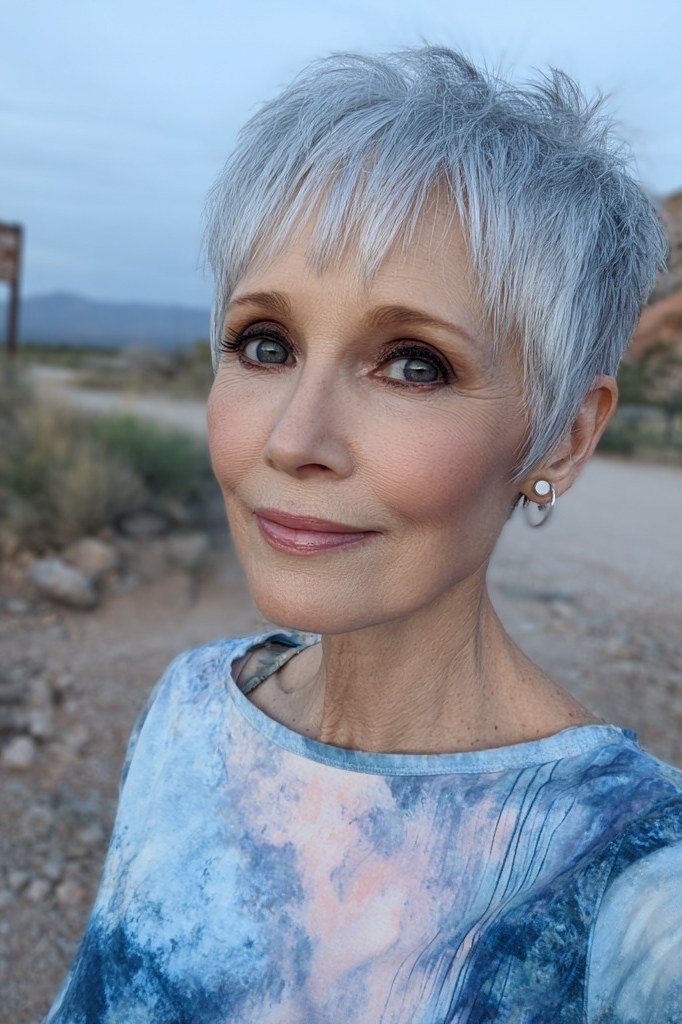 Grey pixie haircut for women over 50: silver pixie with bangs, front view, outdoor background