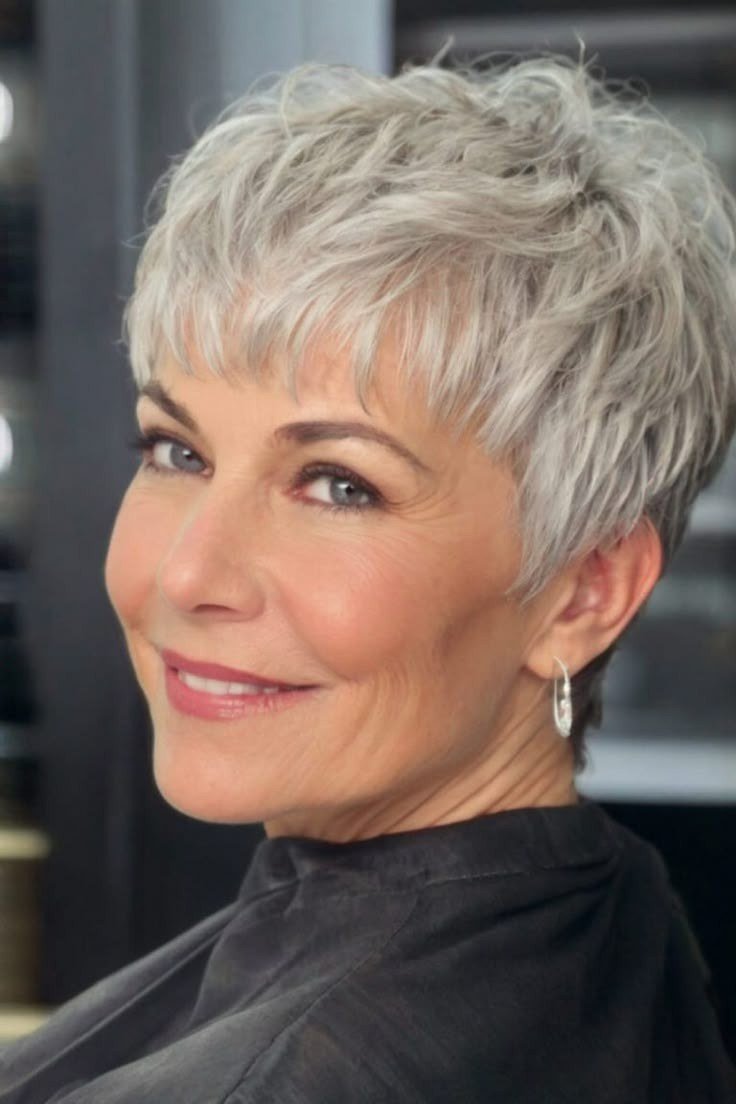 Grey pixie haircut for women over 50: grey spiky pixie, front view, dark background