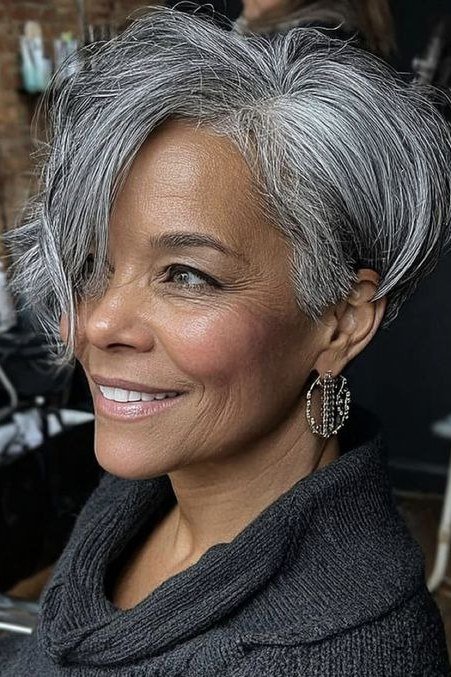 Grey pixie haircut for women over 50: silver pixie, front view, smiling, blue top