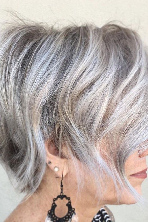 Wavy layered bob hairstyle for women over 50: silver wavy bob, side view, statement earring