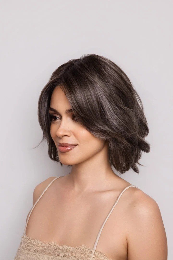Wavy layered bob hairstyle for women over 50: dark wavy bob, side view, deep brunette-grey