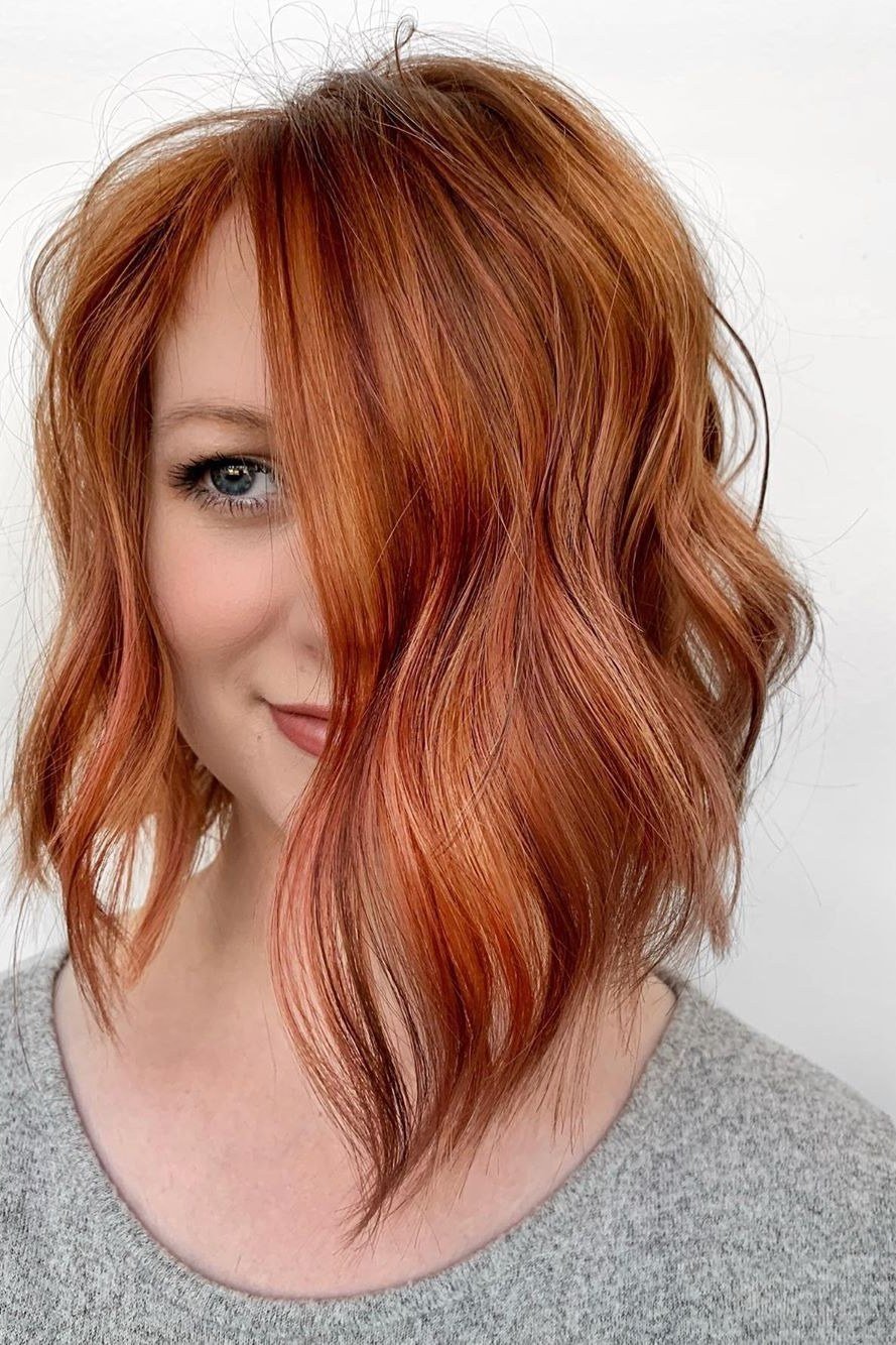 Wavy layered bob hairstyle for women over 50: copper wavy bob, front view, fiery waves