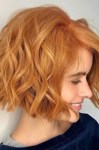 Wavy layered bob hairstyle for women over 50: copper curly bob, side view, tight waves