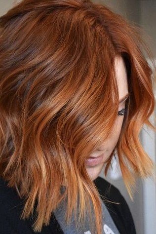Wavy layered bob hairstyle for women over 50: copper wavy bob, front view, soft auburn waves