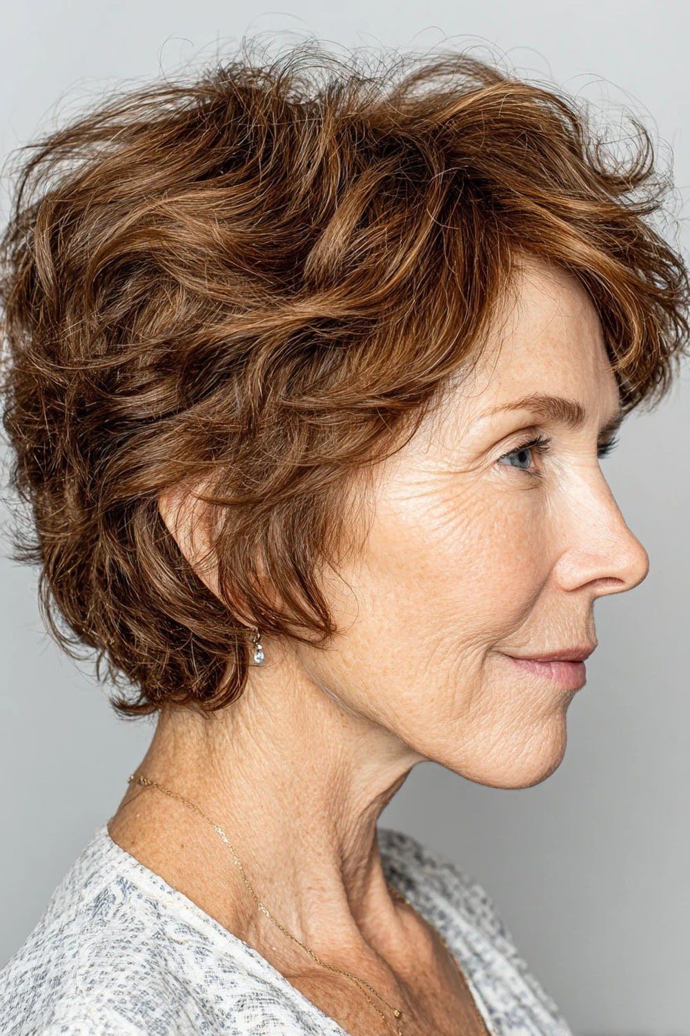 Auburn curly pixie haircut, side profile view