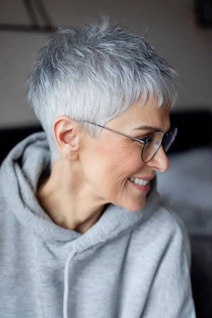 Silver pixie haircut with blue glasses, side profile view