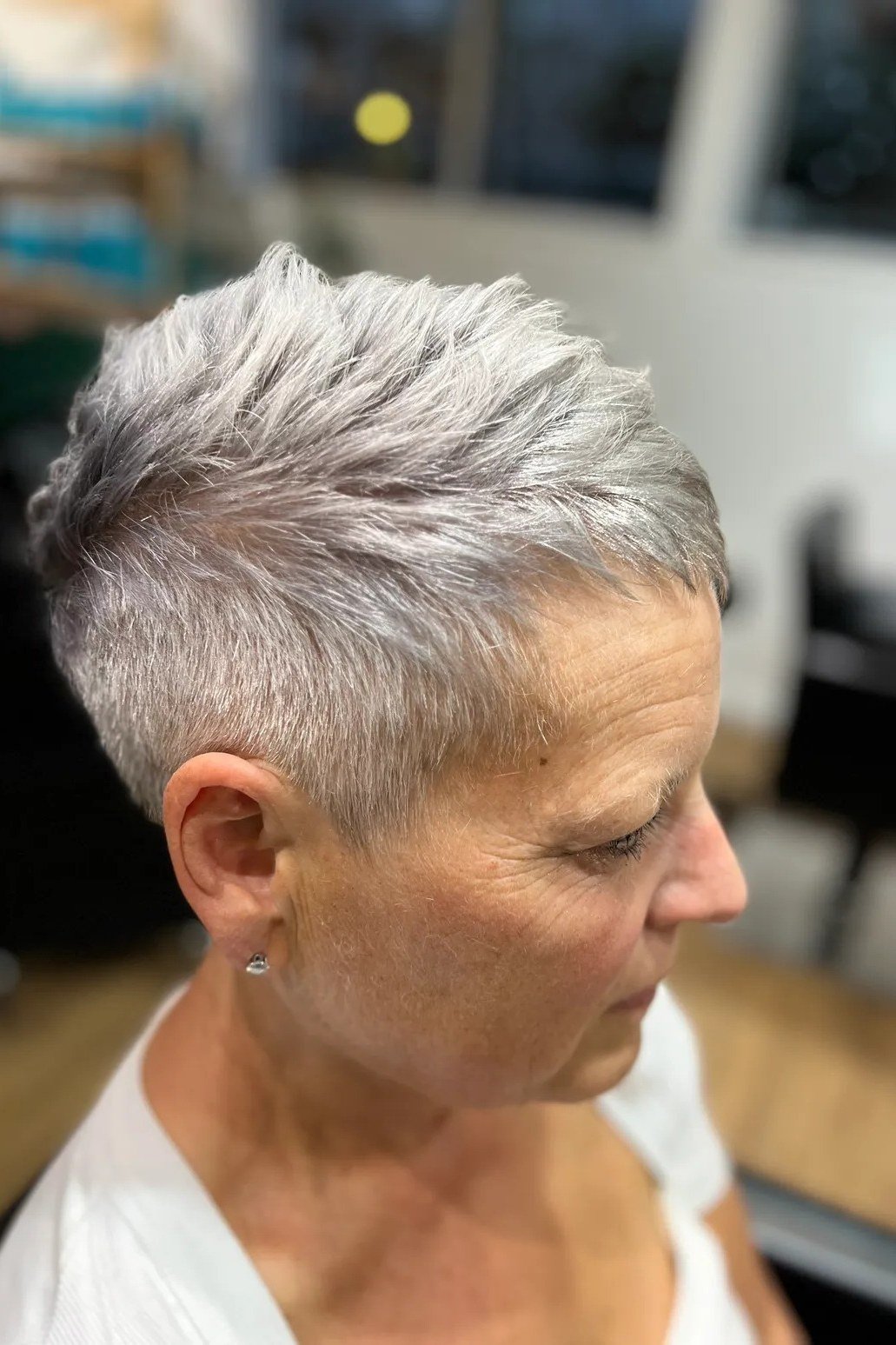 Salt-and-pepper pixie haircut, salon style, side view