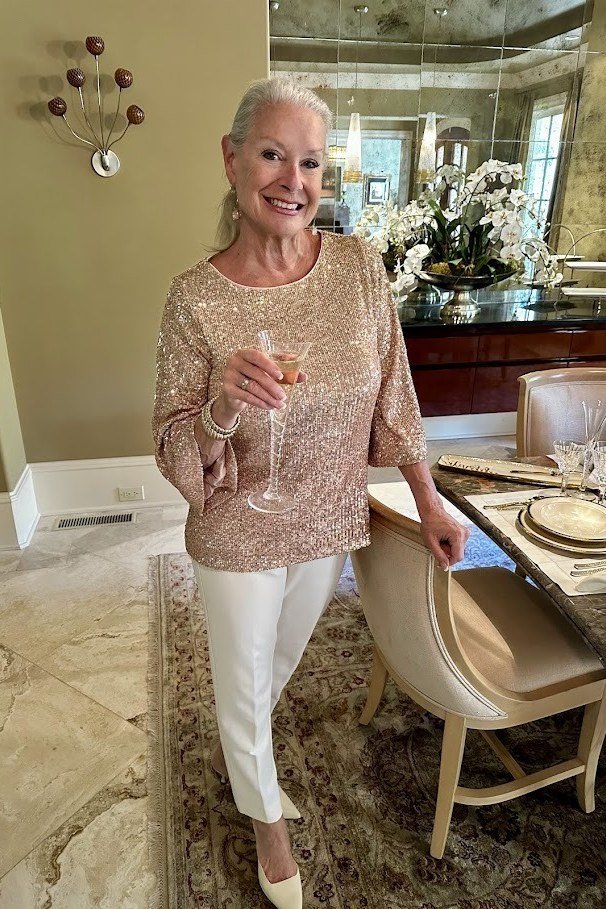 Thanksgiving outfit for women over 50: champagne sequin top with white pants