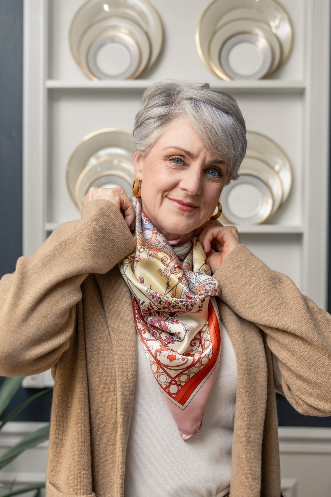 Thanksgiving outfit for women over 50: camel coat with patterned scarf