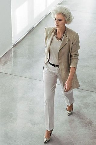 Woman over 50 wearing a taupe blazer with gray top and gray trousers