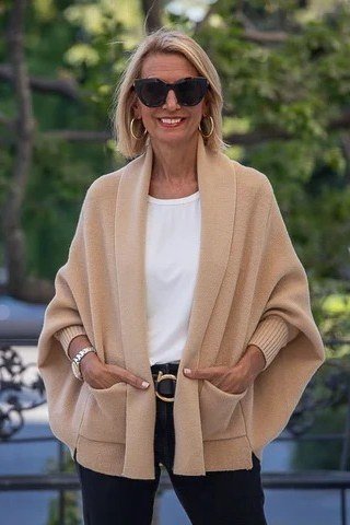 Thanksgiving outfit for women over 50: camel poncho with sunglasses