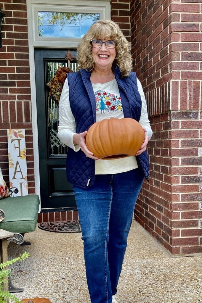 Thanksgiving outfit for women over 50: pumpkin tee with navy vest