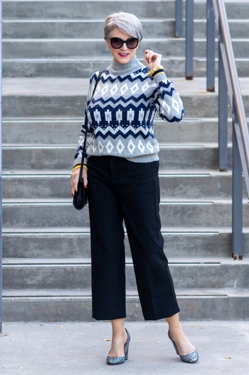 Thanksgiving outfit for women over 50: blue fair isle sweater with black pants