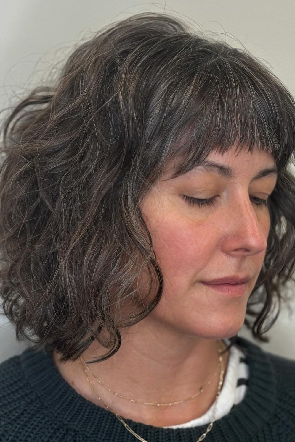 Gray curly bob with bangs for women over 40