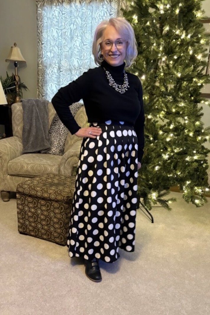 Thanksgiving outfit for women over 50: black turtleneck with polka dot maxi skirt