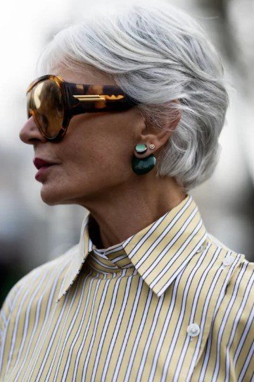 Older woman with sunglasses wearing a cool silver pixie haircut.