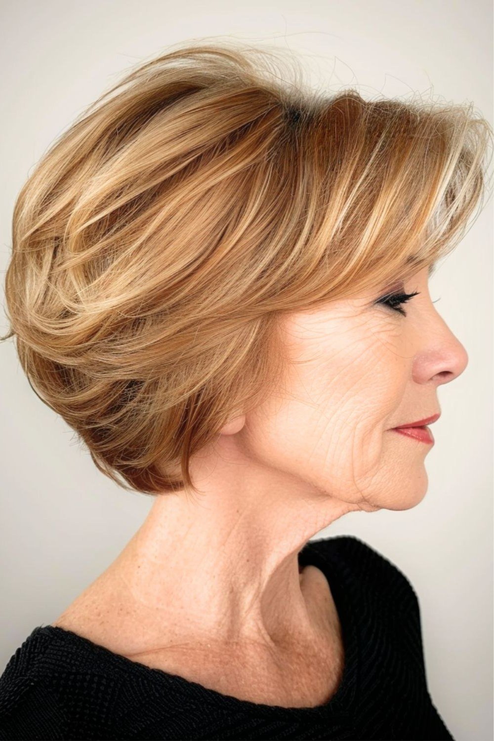 Voluminous golden blonde stacked layered bob in side view
