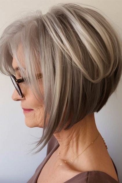 Silver-grey layered bob with glasses, side profile, sleek longer layers for women over 40