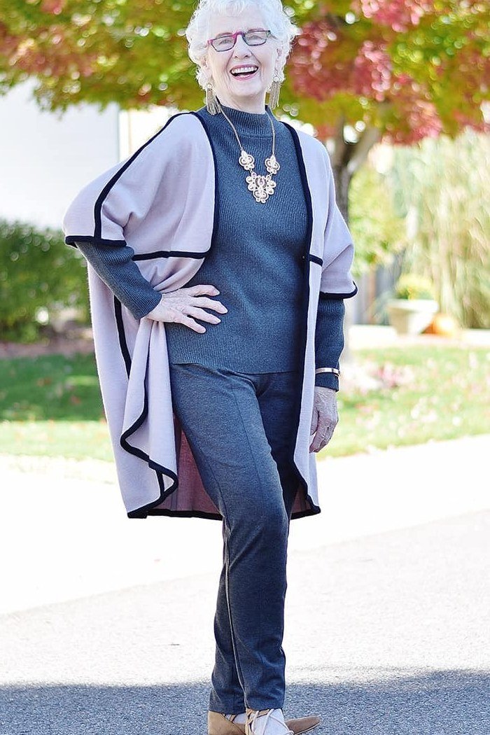 Gray poncho over navy top, dark leggings, white sneakers, outdoors, leggings outfit idea for women over 50