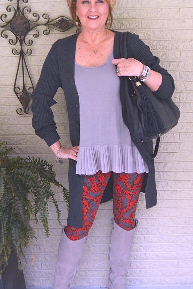 Charcoal cardigan over lavender top, red floral leggings, gray boots, leggings outfit idea for women over 50