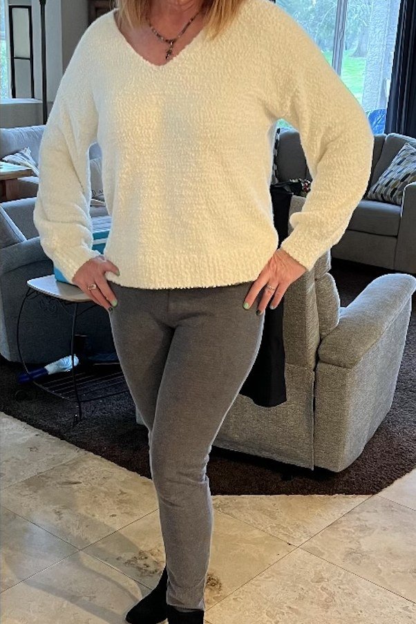 Pale-yellow sweater, gray leggings, black booties, living room, leggings outfit idea for women over 50