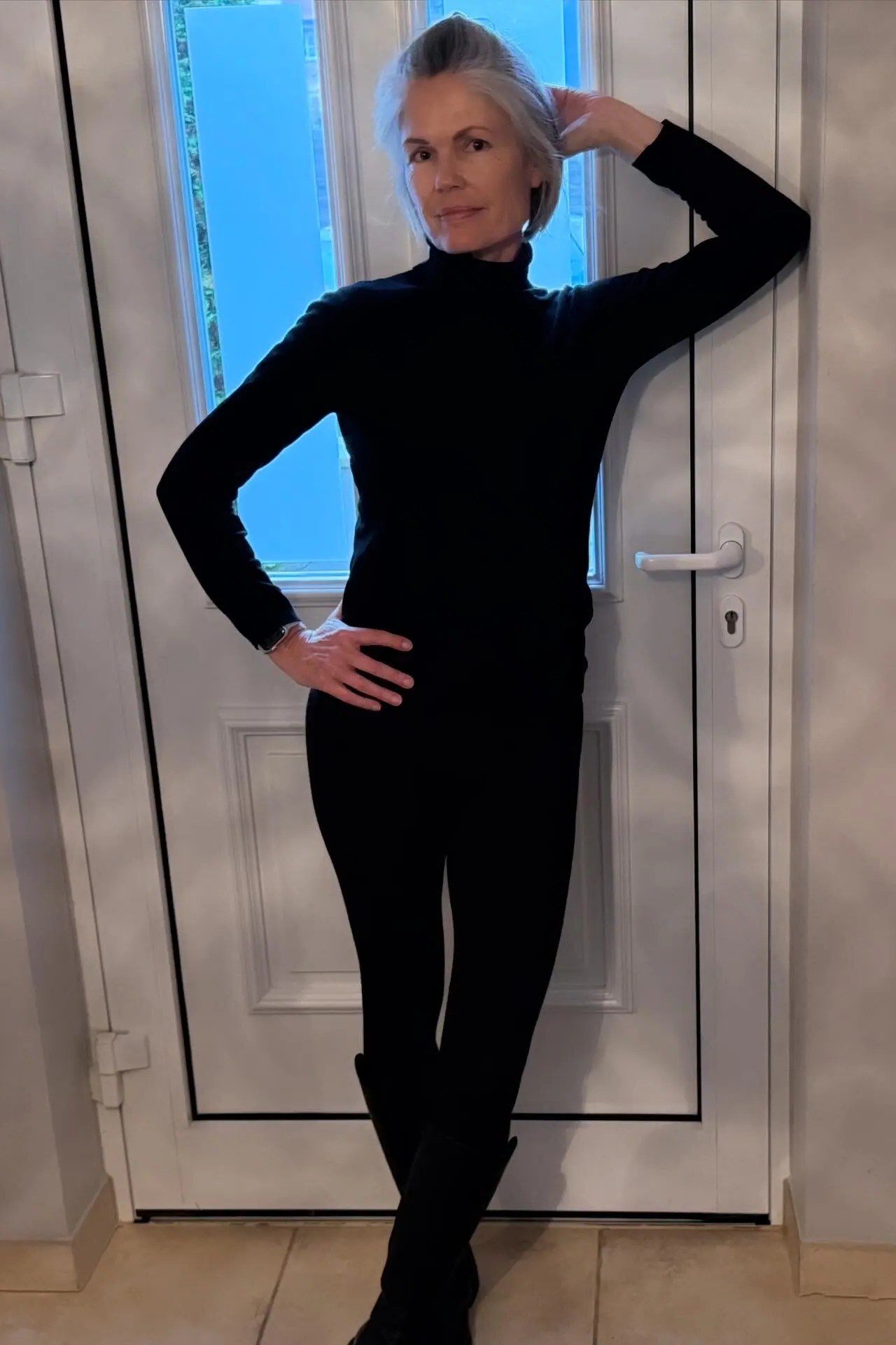 Black turtleneck, black leggings, all-black, doorway, leggings outfit idea for women over 50