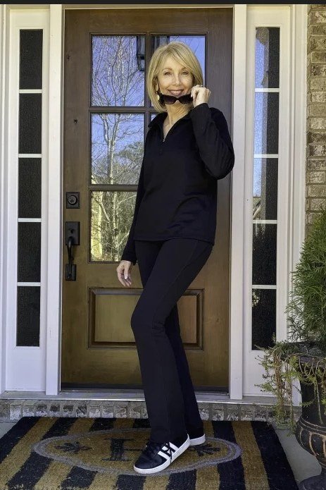 Black top, black leggings, black sneakers, all-black, doorway, leggings outfit idea for women over 50