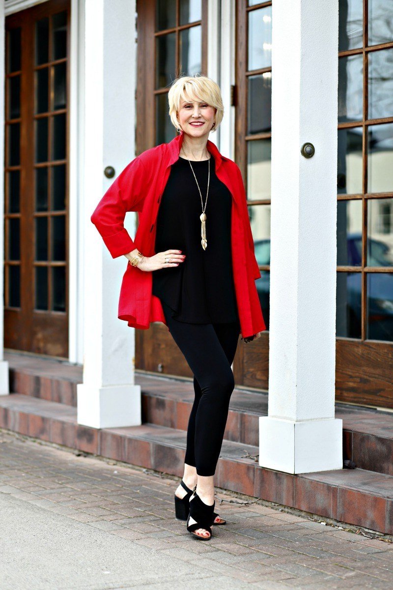 Red blazer over black top, black leggings, black sandals, porch columns, leggings outfit idea for women over 50