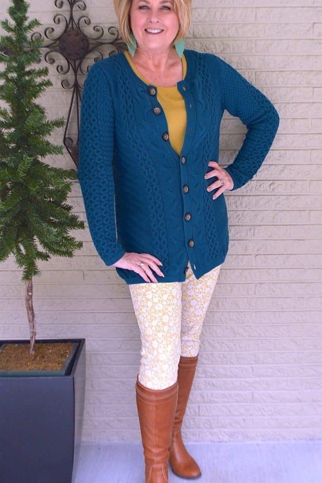 Teal cardigan over mustard top, cream lace leggings, cognac knee boots, leggings outfit idea for women over 50