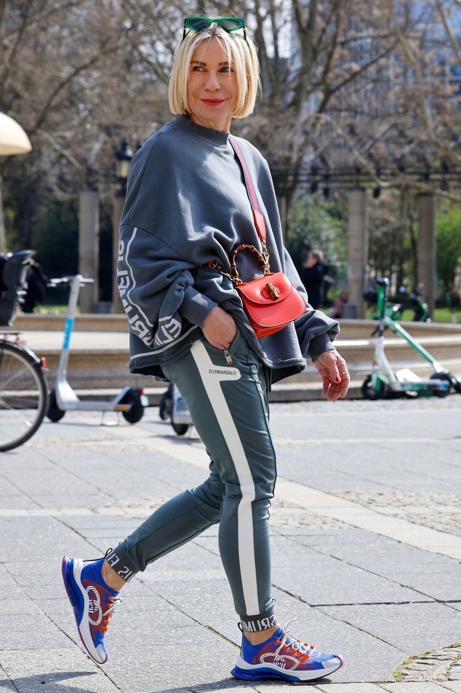 Gray sweatshirt, charcoal side-stripe leggings, colorful sneakers, street style, leggings outfit idea for women over 50