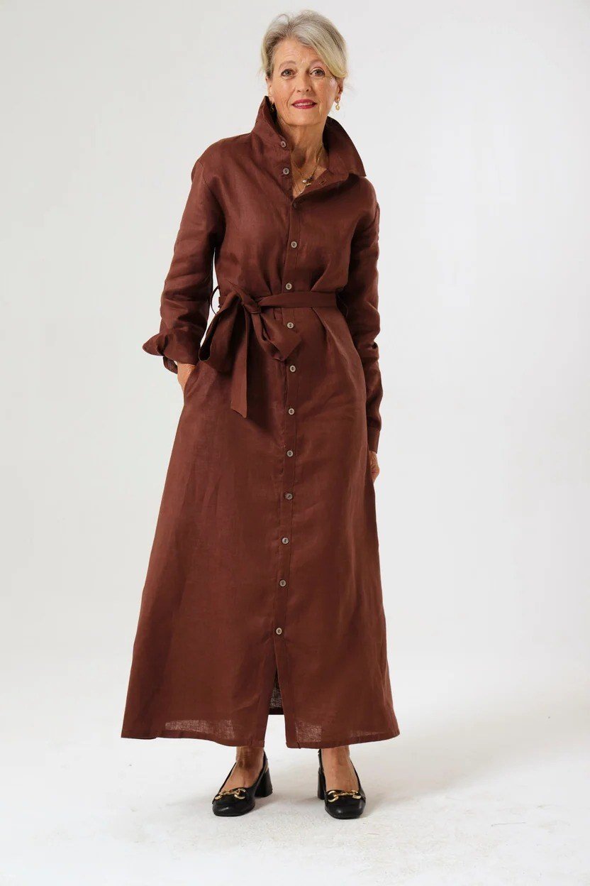 linen summer dresses for women over 60: older woman in rust button-front belted shirt dress maxi in studio