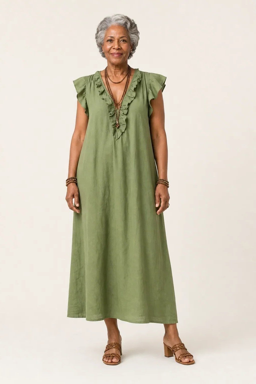 linen summer dresses for women over 60: older woman in green ruffle-neck sleeveless linen maxi dress in studio