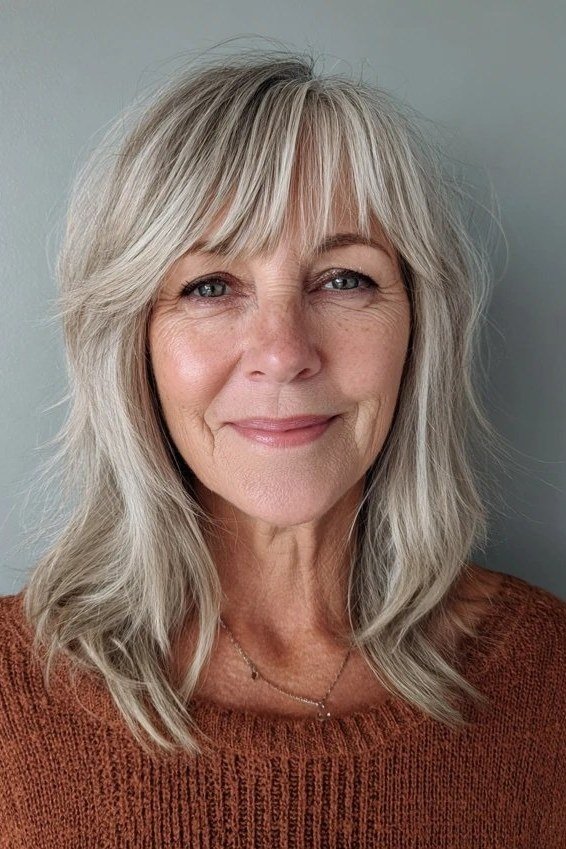 Silver layered medium haircut with bangs for women over 60