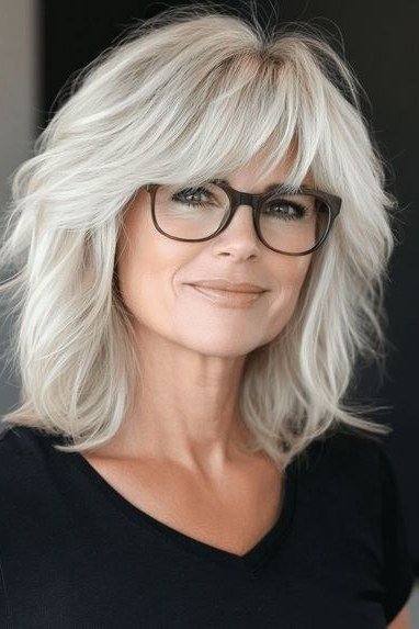 White shag haircut with bangs for women over 60 wearing glasses