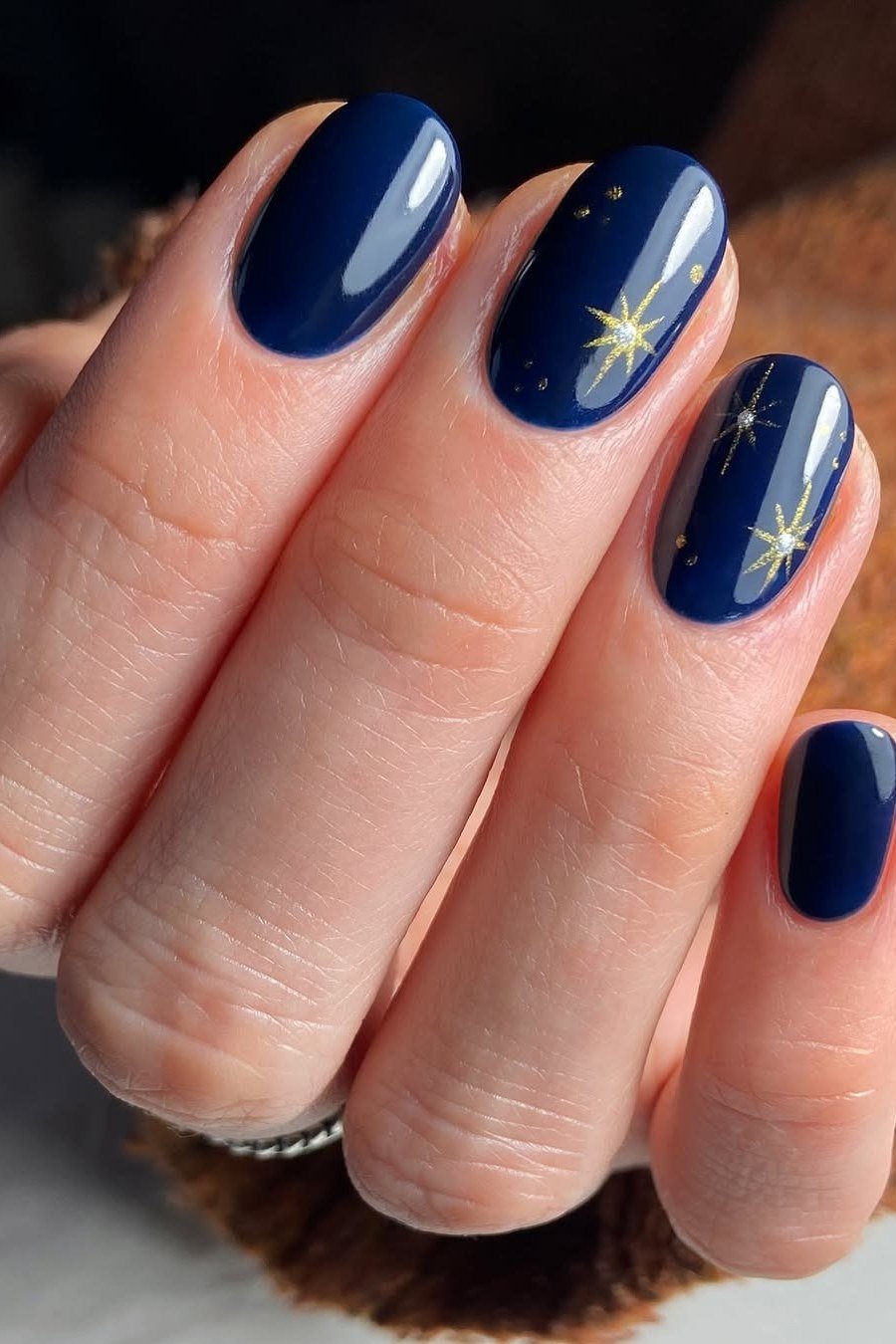 Navy with gold starbursts nails for women over 50 - classy winter nail idea 27