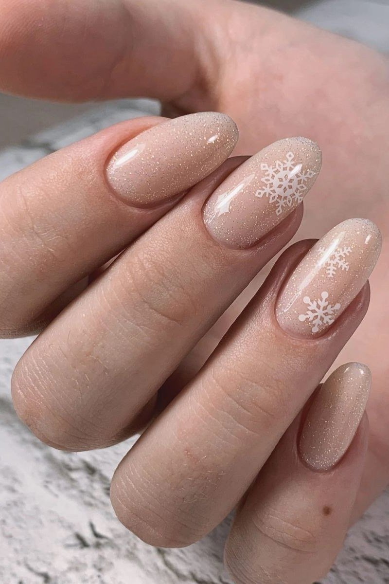Nude with snowflake almond nails for women over 50 - classy winter nail idea 50