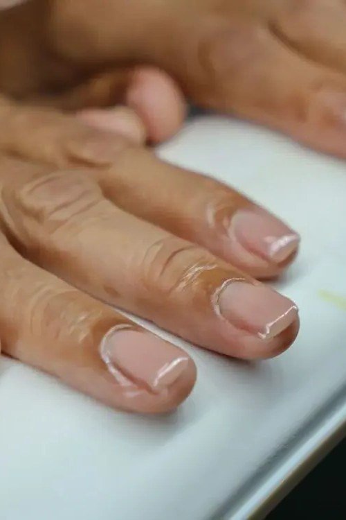Natural nails on mature hands with a gold ring - simple natural nail idea for women over 60