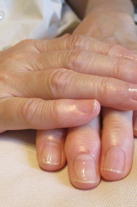 Glossy natural nails with hands stacked - simple natural nail idea for women over 60