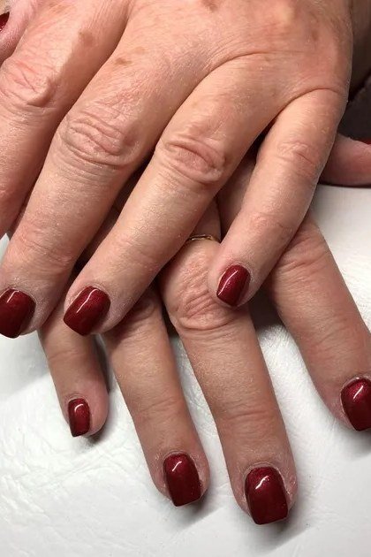 classic bright red glossy medium nails on stacked hands