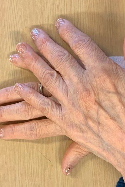 champagne glitter sheer short nails on crossed hands